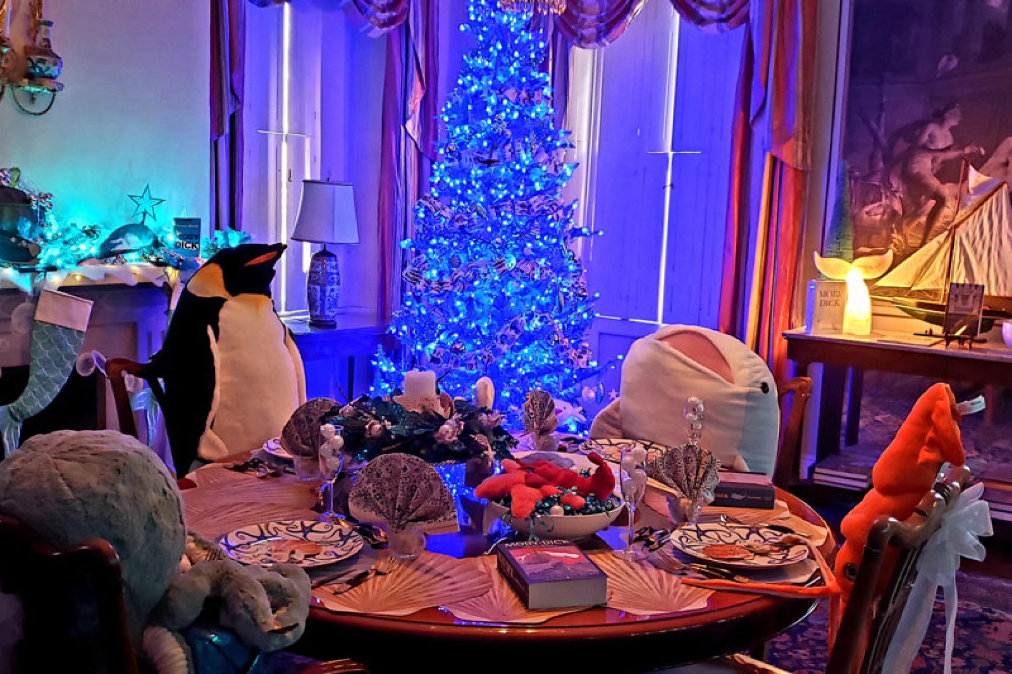 Stuffed animals sitting at a table decorated for the holidays
