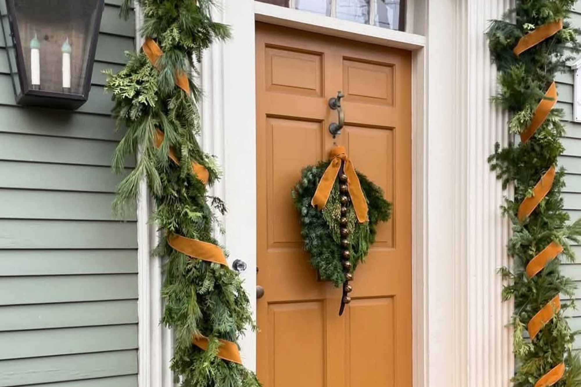 Orange front door decorated for the holidays