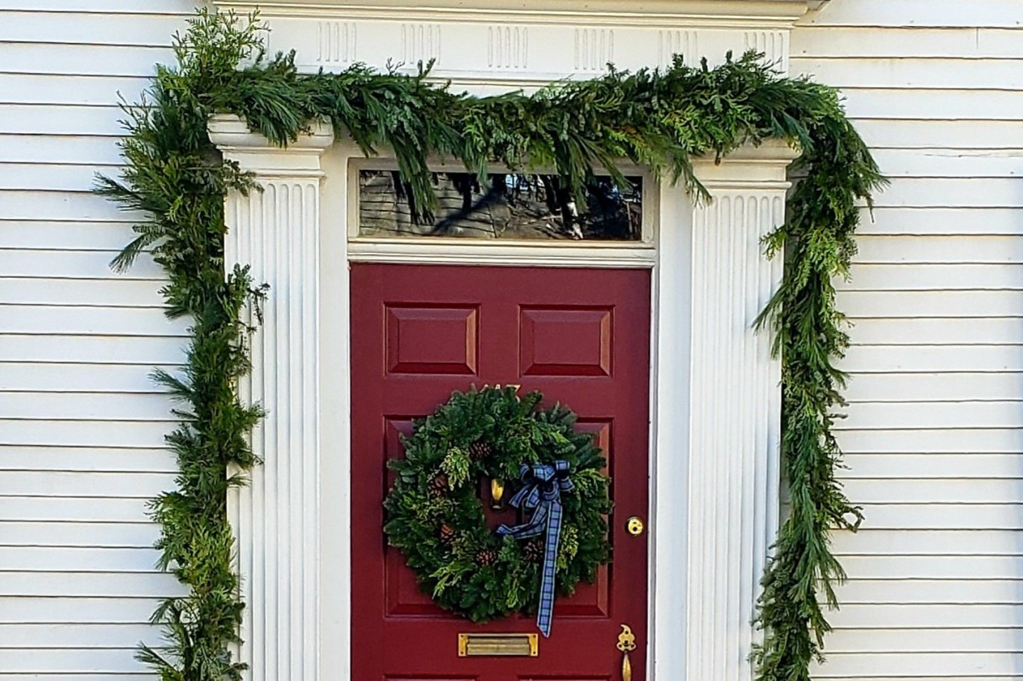 Red front door with wreath and garland