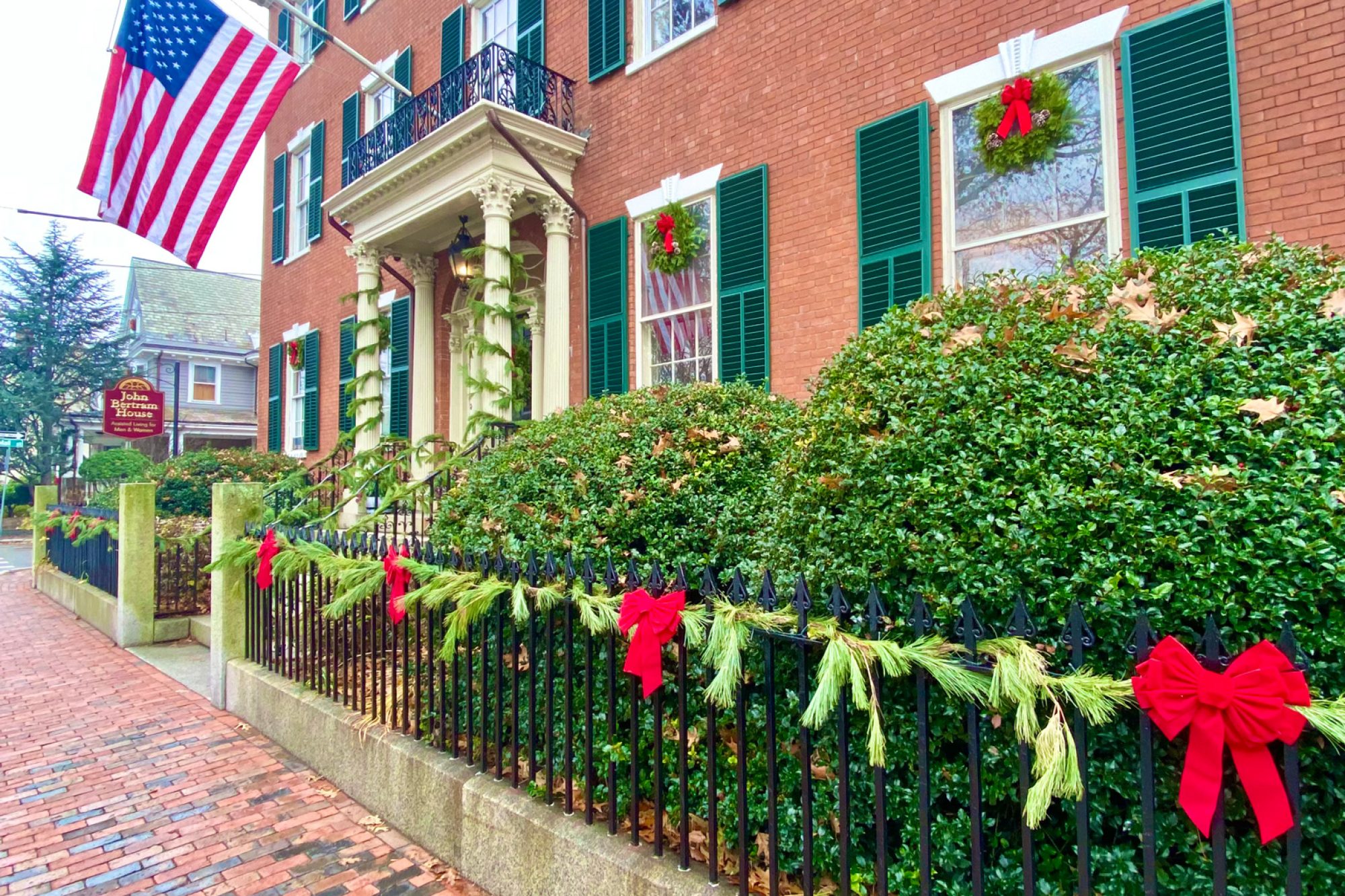 Christmas decorations on a fence and brick building