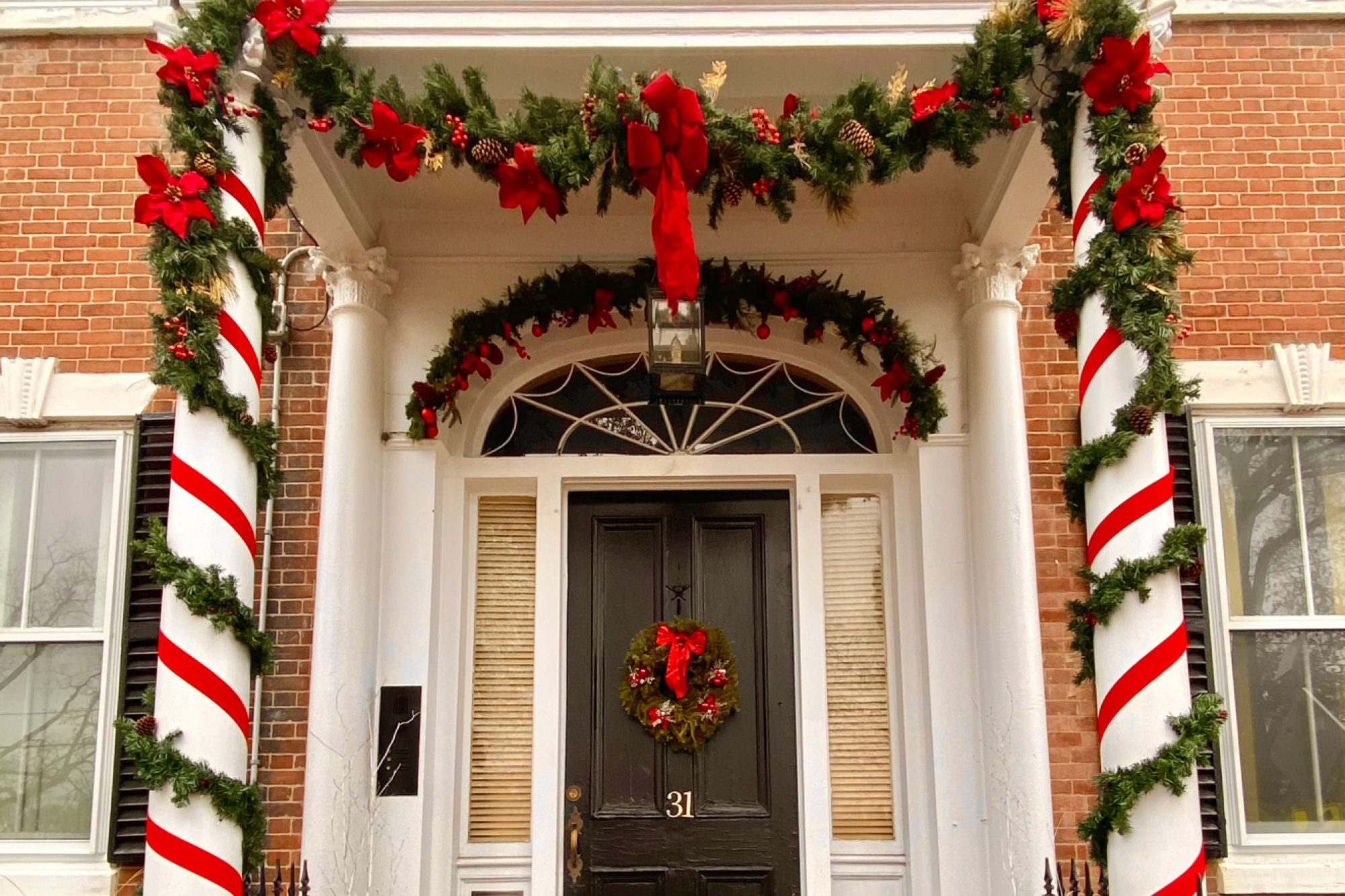 The front door and stoop of a home decorated for Christmas